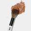 One end of the Makeup By Mario's F2 Dual-Ended Powder Brush dipped in powder bronzer.